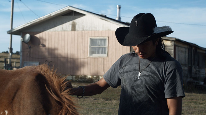 A native American Man next to his horse